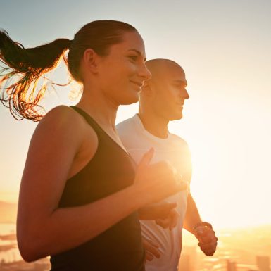 Nothing beats a sunrise run. Shot of a young couple running together outside