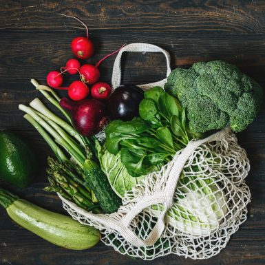 Vegetables broccoli, salad, eggplant,avocado,radish in a mesh bag. Zero waste healthy shopping concept.